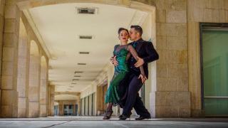 Couple dansant le tango argentin en étreinte fermée sur une piste
